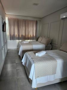 a hotel room with two beds and a couch at Murano Suits Hotel in João Pessoa