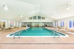 - une piscine dans une grande pièce avec des tables et des chaises dans l'établissement Berkshire Mountain Lodge, à Pittsfield