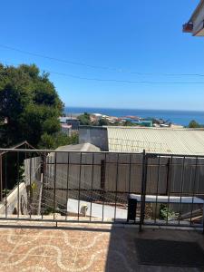 a fence with a view of a building and the ocean at Family Summer House in Valparaíso