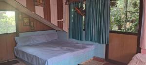 a small bed in a room next to a window at Shree MAHAGANAPATI ROOMS 6 bed room only for gents in Gokarna