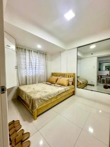 a bedroom with a large bed and a window at 2BR Burnham Hill Condominium in Baguio