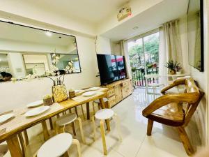 a living room with a table and chairs and a television at 2BR Burnham Hill Condominium in Baguio