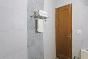 ein Badezimmer mit Toilette und Holztür in der Unterkunft Angel Grand Residency in Greater Noida
