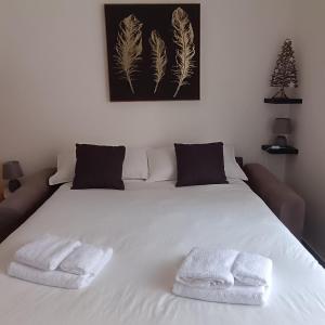 een slaapkamer met een wit bed met twee handdoeken erop bij Sogni di Stelle in Salerno +26 foto's