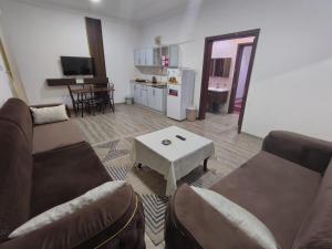a living room with couches and a table and a kitchen at العروسة للشقق المخدومة in Tabuk