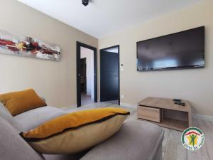 a living room with a couch and a flat screen tv at La villa manon in Florensac