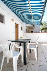 a black table and white chairs on a patio at M377 - Marcelli, bilocale con corte esterna e posto auto in Marcelli