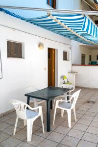 a black table and two white chairs on a patio at M377 - Marcelli, bilocale con corte esterna e posto auto in Marcelli