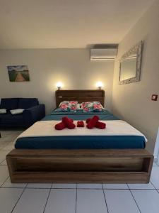 een slaapkamer met een bed met twee rode kussens erop bij Yucca Sea View in Le Gosier