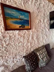 een schilderij aan een muur naast een bed bij Recodo de mar in Aguas Dulces