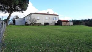 een oud wit huis in een grasveld bij Les hirondelles de montsec in Pampelonne