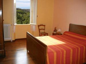 een slaapkamer met een bed en een groot raam bij Les hirondelles de montsec in Pampelonne