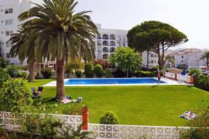 een groot groen park met palmbomen voor een gebouw bij Neenies Nerja - Carabeo Luxury Apartment in Nerja
