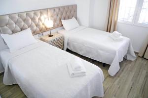 een hotelkamer met twee bedden met witte lakens bij Neenies Nerja - Carabeo Luxury Apartment in Nerja +19 foto's