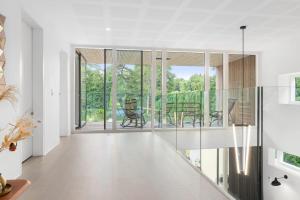 un soggiorno con pareti bianche e pareti in vetro di Exclusive Duplex Mansion with Jacuzzi & Pool a Charlottenlund Altre 29 foto