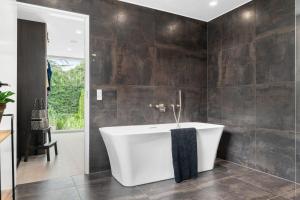 bagno con vasca bianca in una stanza di Exclusive Duplex Mansion with Jacuzzi & Pool a Charlottenlund