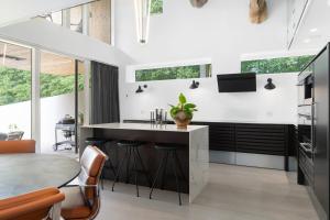 una cucina con una grande isola con sgabelli da bar di Exclusive Duplex Mansion with Jacuzzi & Pool a Charlottenlund