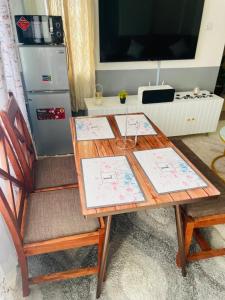 een houten tafel met twee stoelen en een televisie bij Le Comfort in Eldoret