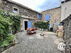 a patio with a table and chairs in front of a building at Le gite fleuri in Limousis
