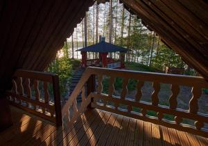 een houten terras met een tafel en een parasol bij Capture Nordic Wilderness Camp in Ilomantsi