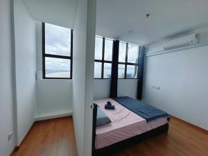 a bedroom with a bed and two windows at Make Memories Residence 2BR Summer Mall Kota Samarahan in Kota Samarahan