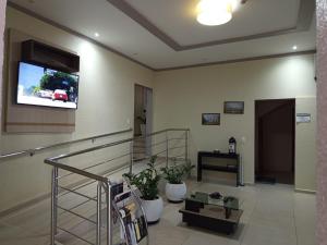a living room with a staircase and a tv on the wall at Hotel BLESS in Cascavel
