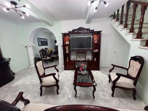 a living room with a tv and chairs and a table at Casa X-lapac in Valladolid
