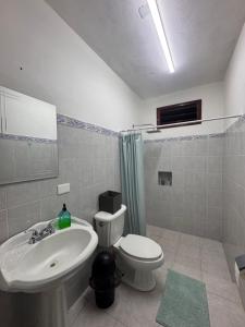 a bathroom with a white sink and a toilet at Casa X-lapac in Valladolid +21 photos