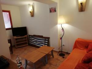 a living room with a couch and a table at La cave de jean in Gardie