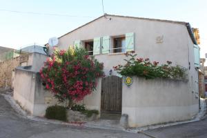 a house with a gate and flowers on it at La cave de jean in Gardie