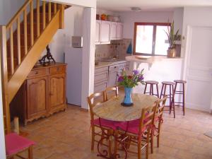 a kitchen with a table with a vase of flowers on it at La cave de jean in Gardie