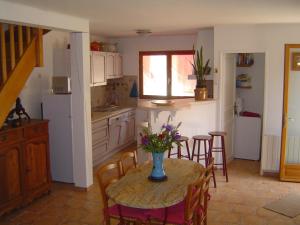 a kitchen with a table with a vase of flowers on it at La cave de jean in Gardie +16 photos