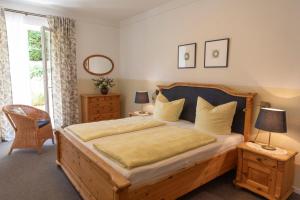 una camera da letto con un grande letto in legno con lenzuola gialle di Gästehaus Pfeiffer a Bad Mergentheim
