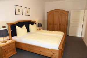 una camera da letto con un letto grande con struttura in legno di Gästehaus Pfeiffer a Bad Mergentheim