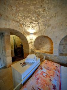 een kamer met een bed en een stenen muur bij il trullo di giada e mattia in Alberobello