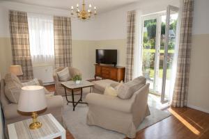 un soggiorno con divani e TV a schermo piatto di Gästehaus Pfeiffer a Bad Mergentheim