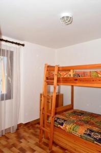 ein Schlafzimmer mit zwei Etagenbetten und einem Fenster in der Unterkunft Les lupins in Bolquere