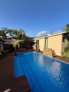 una grande piscina blu accanto a una casa di Zananas Bungalow privé chez l'habitant a Saint-Paul