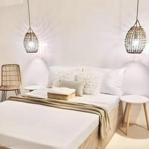 a white bedroom with a bed and two tables at EB Home Apartment in Mactan Island