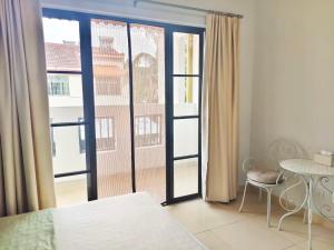 - une chambre avec une grande fenêtre donnant sur un bâtiment dans l'établissement 闲肆民宿, à Sanya