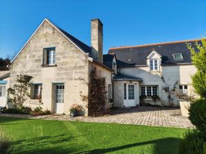a large white house with a grass yard at Le Jardin des Oiseaux in Saint-Michel-sur-Loire