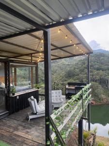 een overdekt terras met stoelen en een piano aan een meer bij Nakawe Guatape in Guatapé