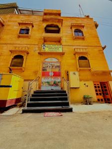een geel gebouw met een trap ervoor bij Hotel Satkar Jaisalmer in Jaisalmer