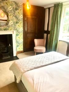 una camera con letto, sedia e camino di Silvermead stables a Plymouth