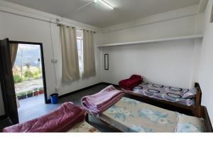 a bedroom with two bunk beds and a window at Vila's Homestay in Kohīma