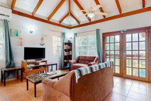 a living room with a couch and a tv at Poseidon House in Riversdale