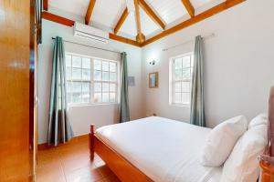a bedroom with a bed and two windows at Poseidon House in Riversdale
