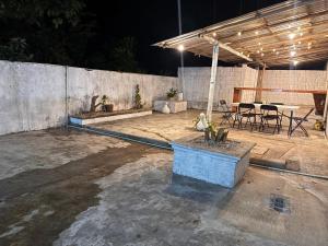 a patio with a table and chairs and a concrete wall at Casa X-lapac in Valladolid