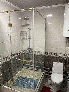 een douchecabine met een toilet in de badkamer bij Nur Hotel in Karakol +4 foto's