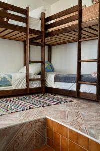 a room with two bunk beds and a tile floor at tamazirt surf house in Taghazout